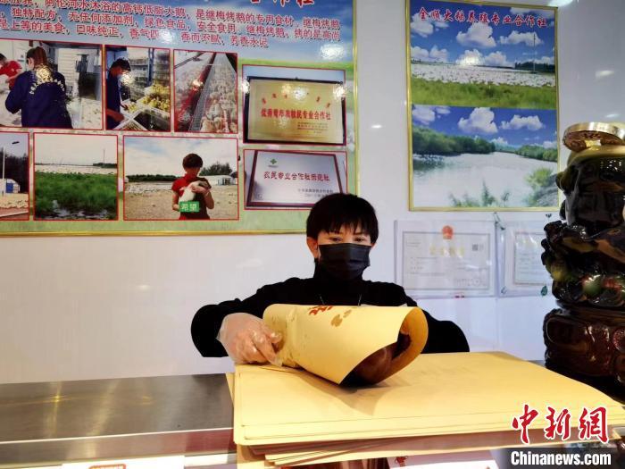 圖為鄭繼梅正在打包烤鵝?！≈x宏秀供圖